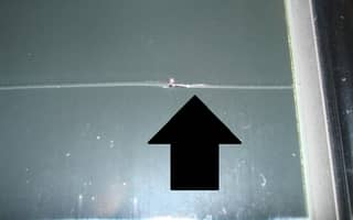 Windshield with stress crack extending to its frame