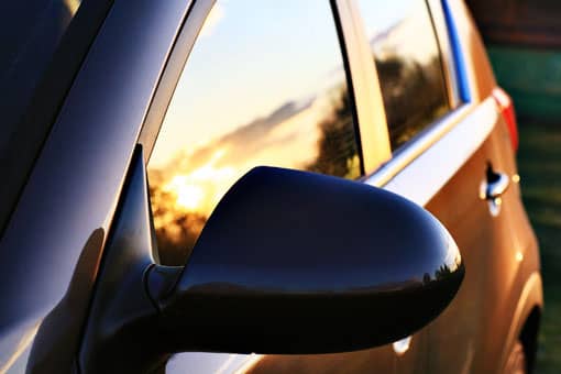 Sunset reflecting off front and rear car door windows