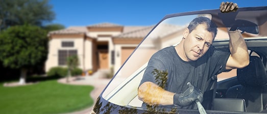 Technician taking old windshield off car