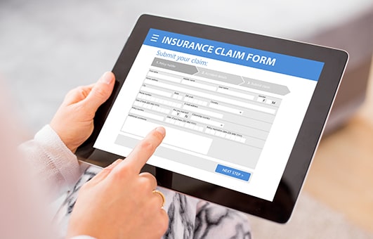 Woman filling out an insurance claim on a tablet